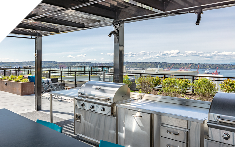 covered grilling area with table and chairs